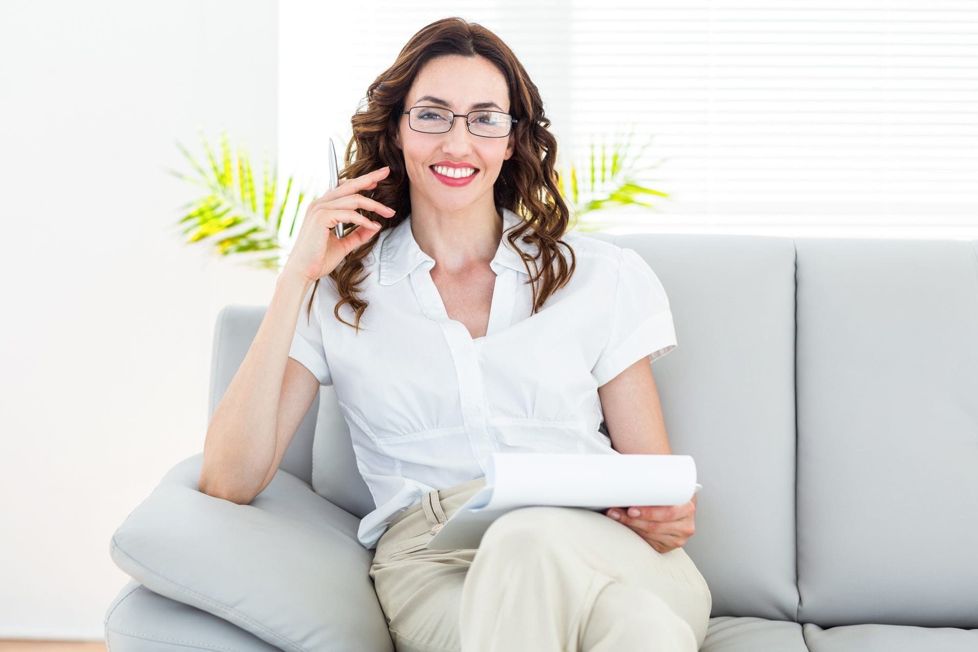 Smiling Therapist Taking Notes On White Background